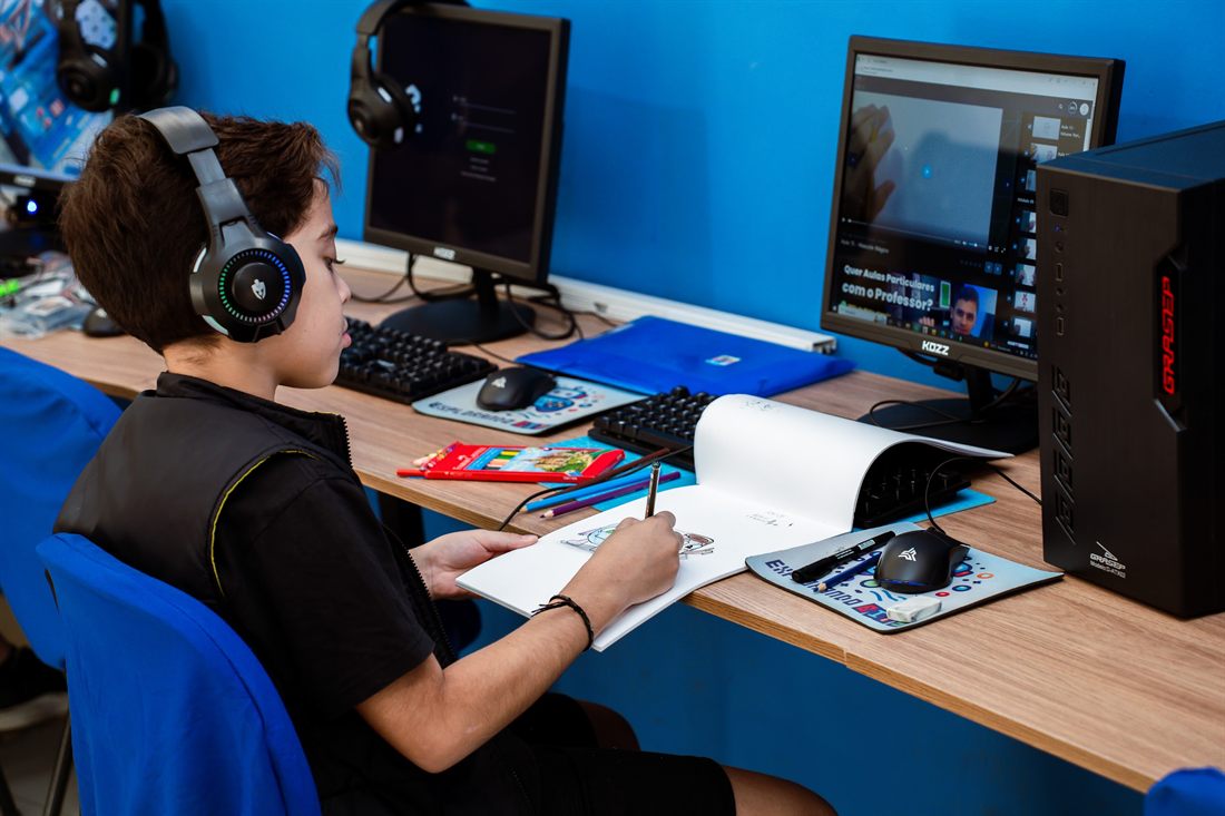Aluno estudando com headset no computador