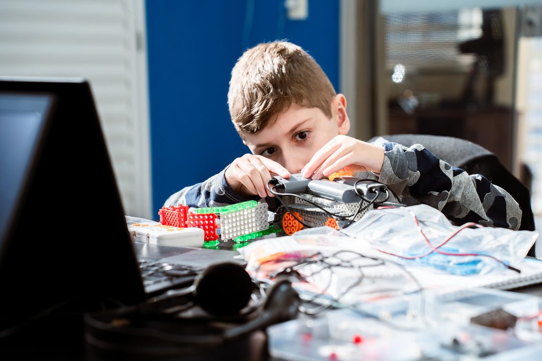 Aluno concentrado montando um projeto de robótica