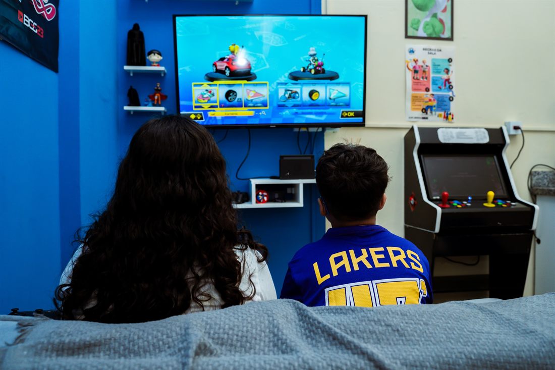 Alunos na área de games com fliperama